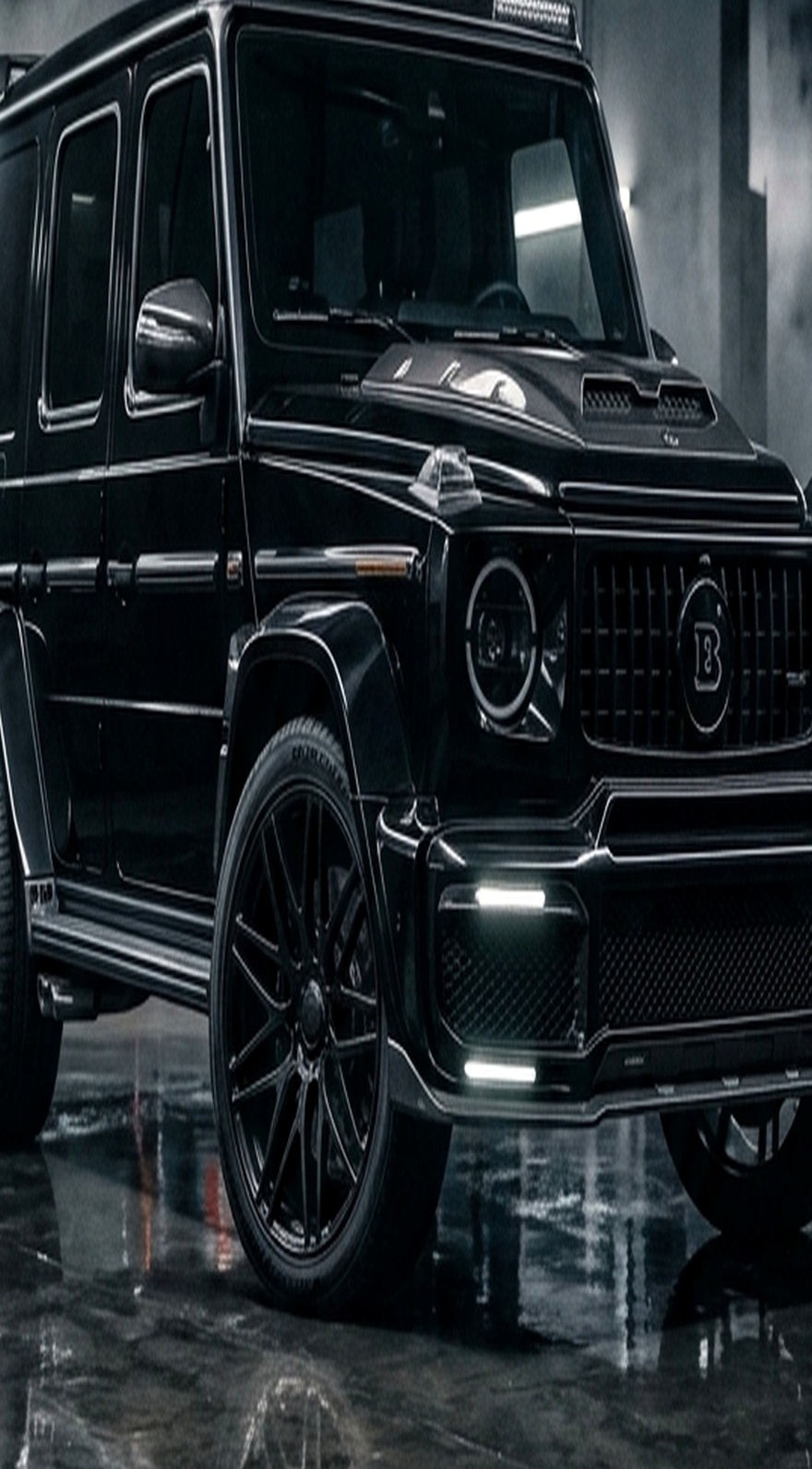 A custom Branders Mercedes G63 navigates a steep, muddy incline beneath an overcast sky.