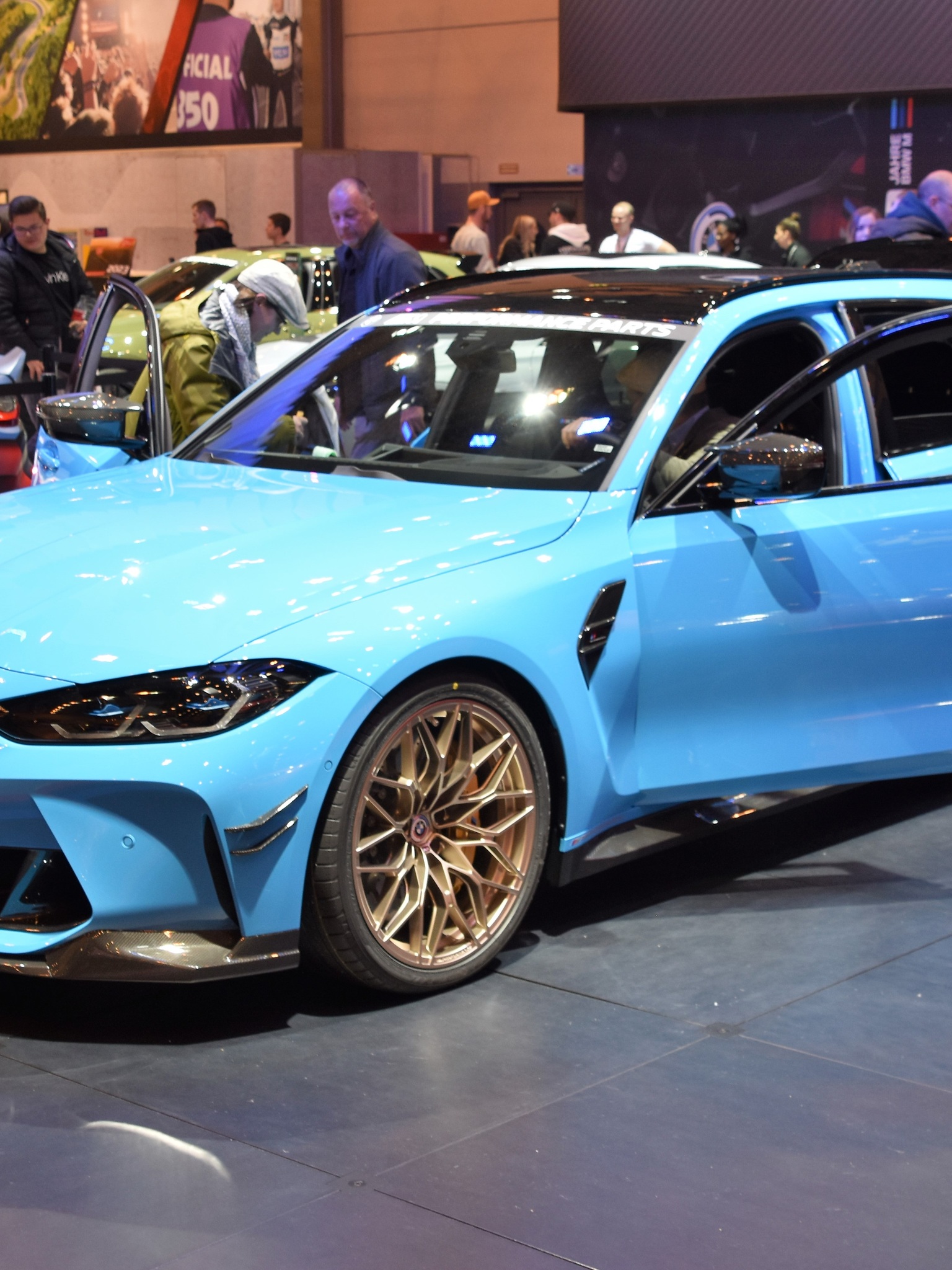 A custom Branders BMW M5 Touring sits elevated on a mechanic lift inside a bright detailing workshop.