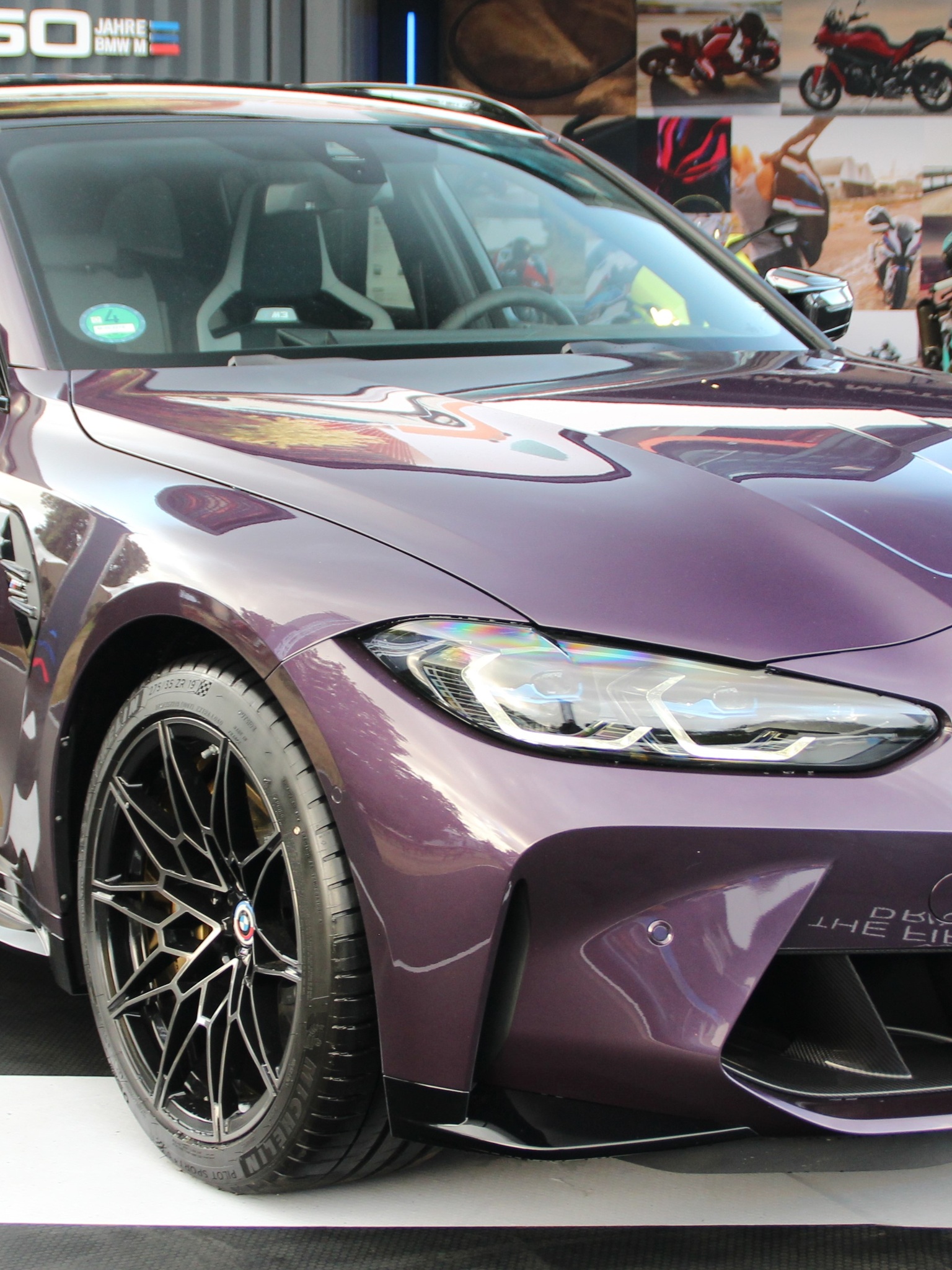 Close-up of the grey exterior body panels and A-pillar on a custom Branders BMW M5 Touring parked inside a brightly lit showroom.