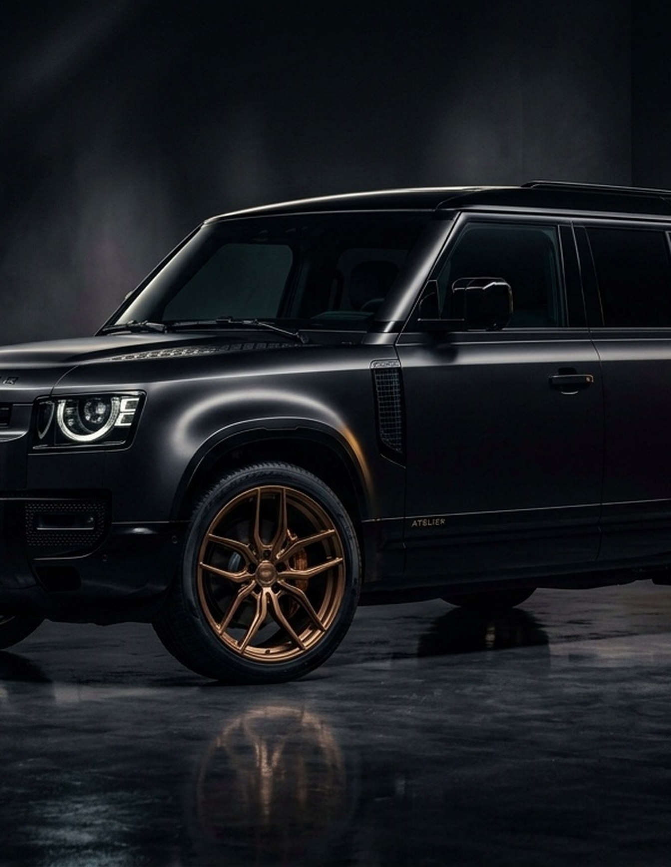 A custom Branders Land Rover Defender 110 with glowing red taillights is parked indoors on a concrete floor.