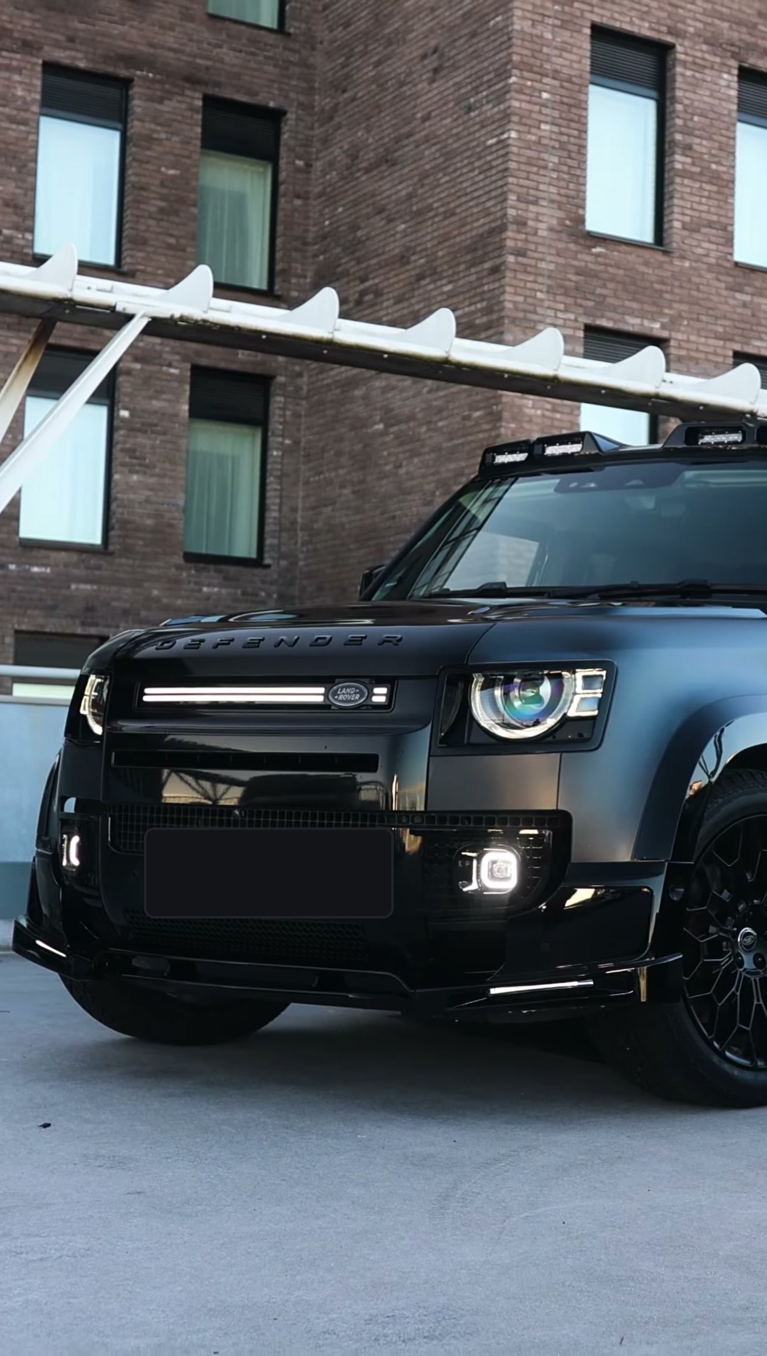 A Branders modified Land Rover Defender 130 outside a stone garage
