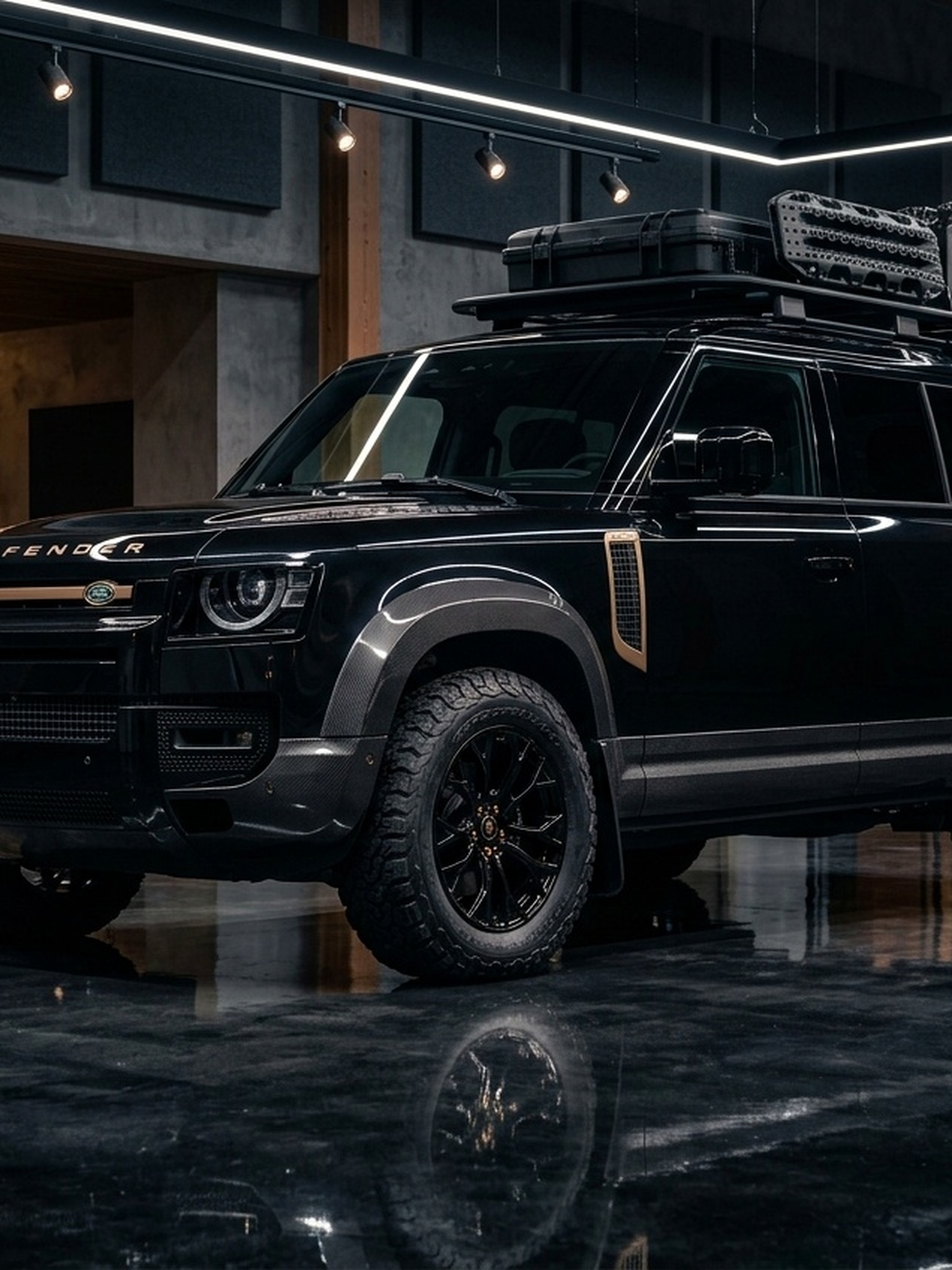 A close-up of the green and black hood on a custom Branders Land Rover Defender 90 parked on a wet asphalt surface.
