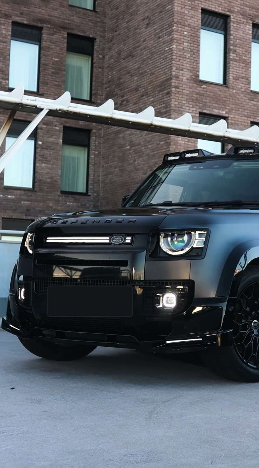 A Branders modified Land Rover Defender 130 outside a stone garage